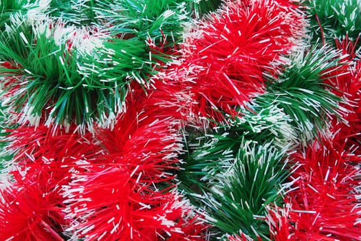 New Year and Christmas decorations, red and green boas for the Christmas tree. Two-color Christmas rain garlands are mixed. Festive decor