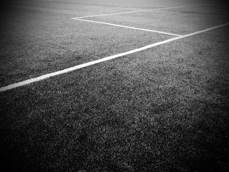 The marking of the football field. White lines no more than 12 cm or 5 inches wide. Football field area. Black and white monochrome photography.