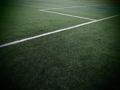 The marking of the football field on the green grass. White lines no more than 12 cm or 5 inches wide. Football field area