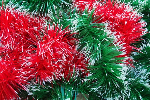 New Year and Christmas decorations, red and green boas for the Christmas tree. Two-color Christmas rain garlands are mixed. Festive decor