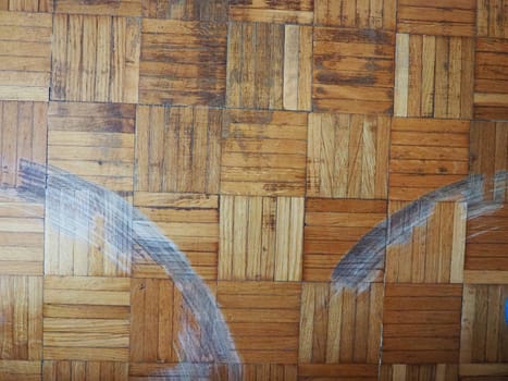 Scratched parquet flooring in the room. Scratches, chips and dents on the floor. Parquet in need of repair