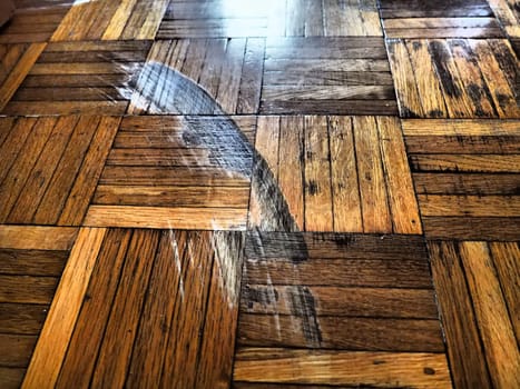 Scratched parquet flooring in the room. Scratches, chips and dents on the floor. Parquet in need of repair