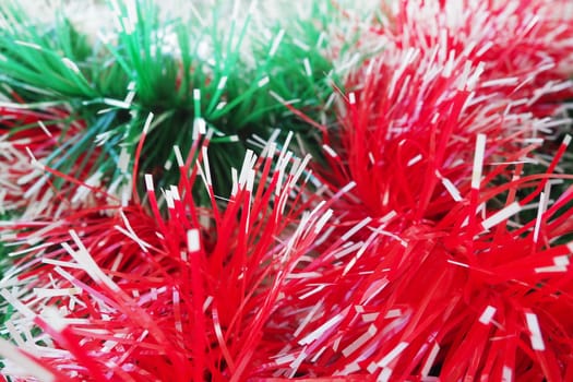 New Year and Christmas decorations, red and green boas for the Christmas tree. Two-color Christmas rain garlands are mixed. Festive decor