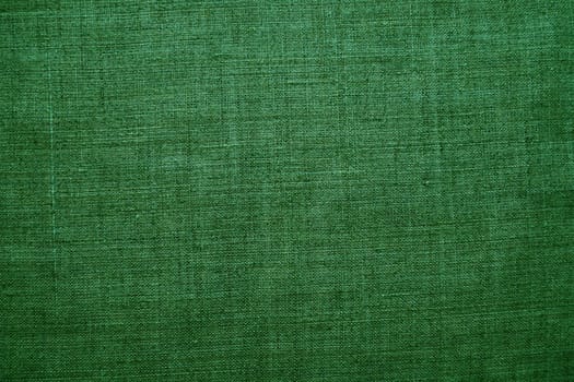 Fabric texture background. Green fabric with weave. Natural slightly wrinkled look of the material. Uniform copy space background. Cotton, canvas or woolen thin fabric laid evenly on the surface