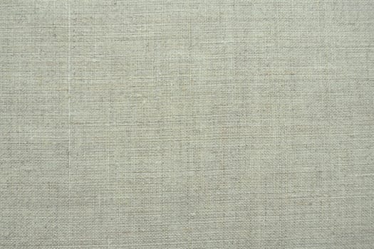 Fabric texture background. Light gray fabric with weave. Natural slightly wrinkled look of the material. Uniform copy space background. Cotton, canvas or woolen thin fabric laid evenly on the surface