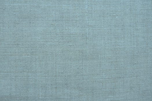 Fabric texture background. Blue fabric with weave. Natural slightly wrinkled look of the material. Uniform copy space background. Cotton, canvas or woolen thin fabric laid evenly on the surface