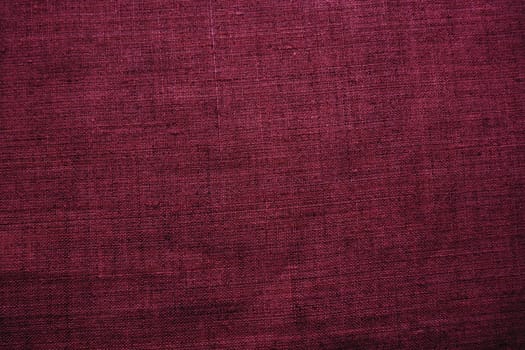 Fabric texture background. Burgundy purple fabric with weave. Natural slightly wrinkled look of the material. Uniform copy space background. Cotton, canvas or woolen thin fabric laid on the surface