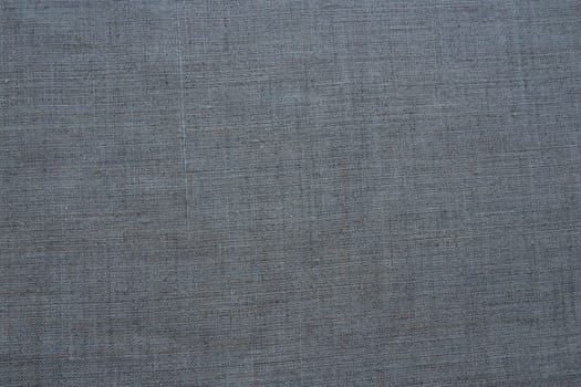 Fabric texture background. Gray fabric with weave. Natural slightly wrinkled look of the material. Uniform copy space background. Cotton, canvas or woolen thin fabric laid evenly on the surface