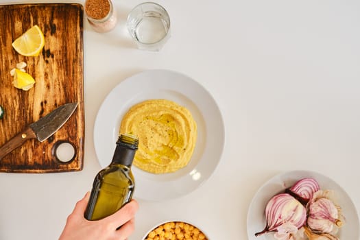 Adding olive oil to hummus, top view
