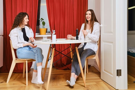 Two laughing young women in dining room