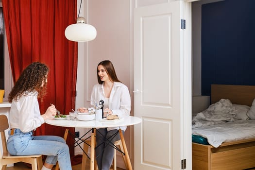 Woman spent night at friend's house and they have breakfast in the morning together
