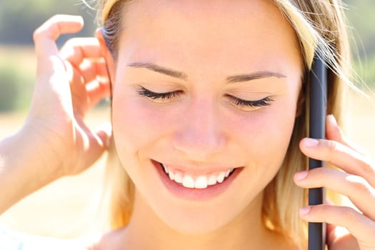 Happy teen talks on phone outdoors