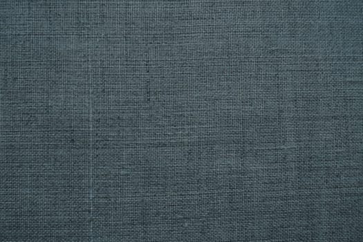 Fabric texture background. Dark gray fabric with weave. Natural slightly wrinkled look of the material. Uniform copy space background. Cotton, canvas or woolen thin fabric laid evenly on the surface
