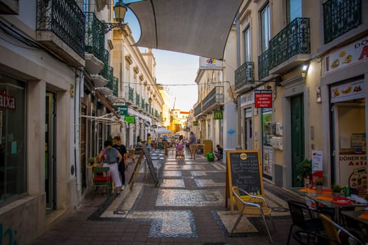 Faro, Portugal, September 2022: View on a cozy street with restaurants and bars in the old town of Faro.