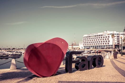 Faro, Portugal, September 2022: View on the I love Faro sign and Eva Senses Hotel in the marina of Faro, Portugal.