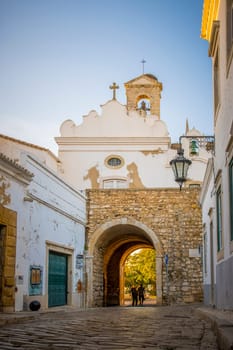 Faro, Portugal, September 2022: View on Arco da Vila in Faro, Portugal. Neoclassical arch which is the entrance to the old town.