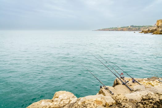 Fishing rods on the rocks of the coast of Cascais, Portugal