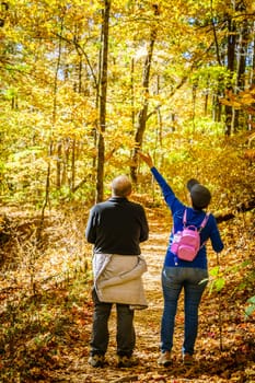 Senior couple is hiking in the woods in North Carolina in fall