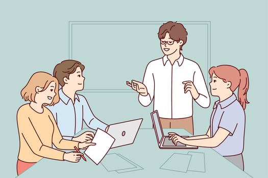 Successful people working in modern startup listening to colleague presentation. Programmers are sitting at table with laptops and papers waiting to receive assignment from boss. Flat vector image