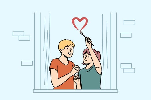 Happy couple draw heart on window