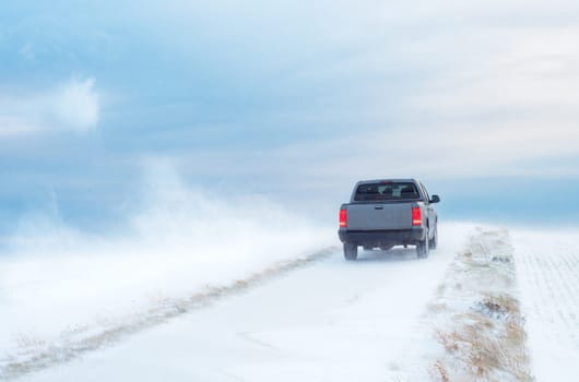 Pick-Up Truck on road in winter with heavy wind