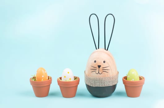 Cute easter bunny, baby rabbit with eggs in a flower pot, spring holiday greeting card