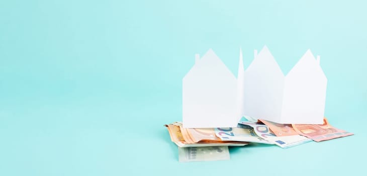 Paper house with Euro banknotes, planning to buy, build or rent a new home, real estate concept, owning property, bank loan