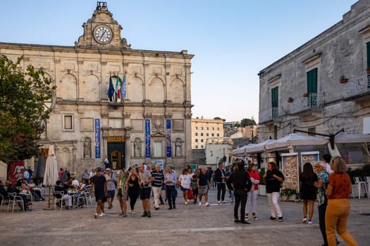 Matera, Italy - September 14, 2019: Tourists during a walk on Cobblestone street in the Sassi di Matera a historic district in the city of Matera. Basilicata. Italy