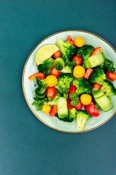 Light salad with broccoli, tomato, cucumber, bell pepper and physalis. Top view