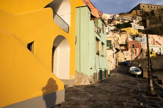 View of the Port of Corricella with lots of colorful houses on a sunny day in Procida Island, Italy.