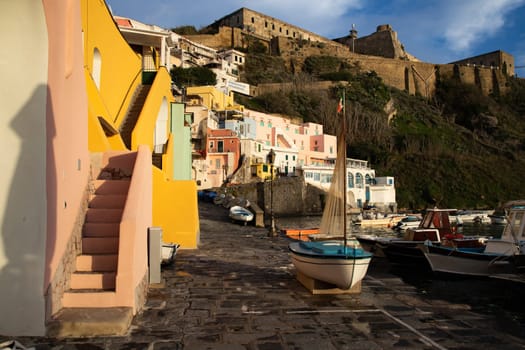 View of the Port of Corricella with lots of colorful houses on a sunny day in Procida Island, Italy.