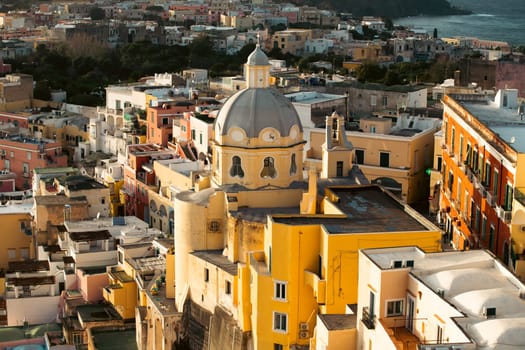 View of the Port of Corricella with lots of colorful houses in the sunset, Procida Island, Italy.