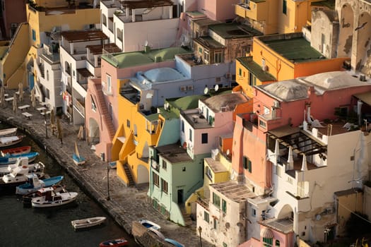 View of the Port of Corricella with lots of colorful houses in the sunset, Procida Island, Italy.