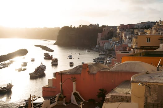 View of the Port of Corricella with lots of colorful houses on a sunny day in Procida Island, Italy.