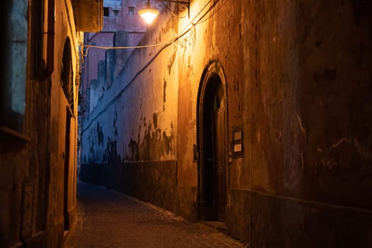 Tiny narrow streets with colorful houses at night on Procida Island, Italy.