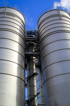Two huge bunkers, storage or silos for industrial raw materials.