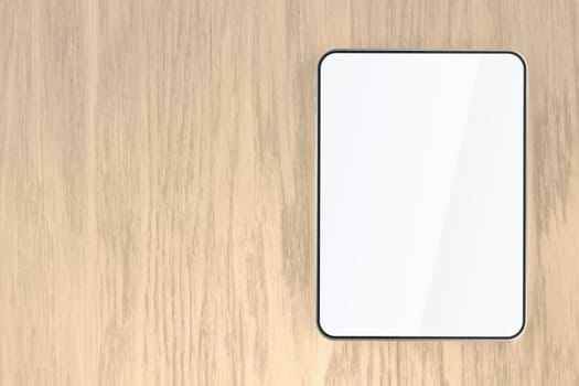 Tablet with empty screen on wooden desk, top view