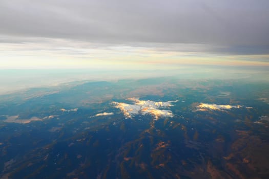 Turkey, Ankara. View from airplane window to the Turkish mountains, lakes and snowy peaks. Layered clouds and horizon. Lakes Saryar, Nallihan and Camlidere. Departure from Esenboga Havalimani Airport.