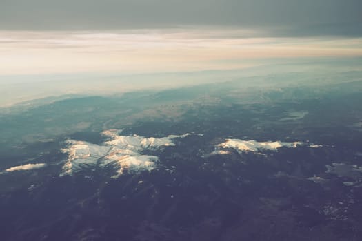 Turkey, Ankara. View from airplane window to the Turkish mountains, lakes and snowy peaks. Layered clouds and horizon. Lakes Saryar, Nallihan and Camlidere. Departure from Esenboga Havalimani Airport.