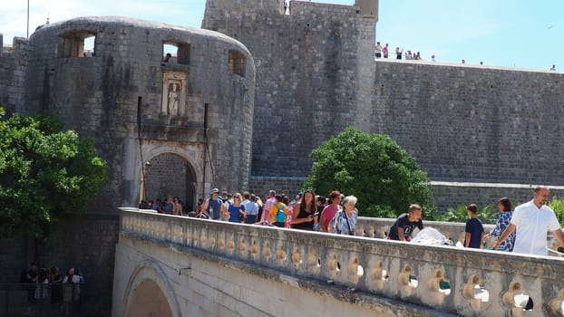 Pile Gate Dubrovnik Croatia August 14 2022 People men and women walk along the stone bridge to the gate of the Old City. Crowd of tourists. Busy entrance. The main entrance to Old Town, busy Pile Gate