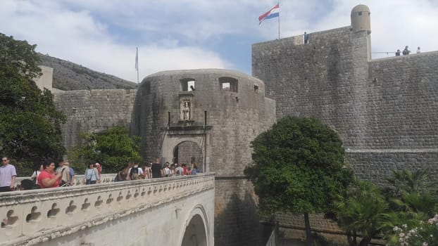 Pile Gate Dubrovnik Croatia August 14 2022 People men and women walk along the stone bridge to the gate of the Old City. Crowd of tourists. Busy entrance. The main entrance to Old Town, busy Pile Gate
