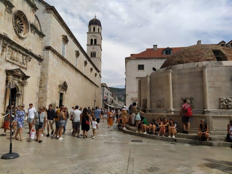 Big Onofrio Fountain, Velika Onofrijeva chesma, Dubrovnik, Croatia. Water supply established during the Quattrocento period. Numerous multinational happy tourists walk on the Stradun 14 August 2022.