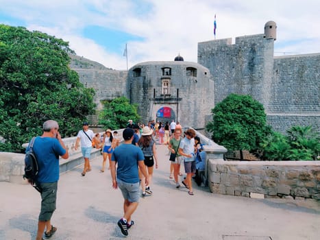 Pile Gate Dubrovnik Croatia August 14 2022 People men and women walk along the stone bridge to the gate of the Old City. Crowd of tourists. Busy entrance. The main entrance to Old Town, busy Pile Gate
