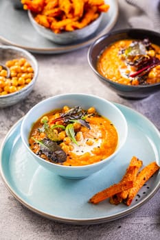Carrot and sweet potato soup with chickpeas and fresh winter herbs, sweet potato fries