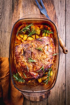 Roasted pork meat with potatoes, rosemary and beer sauce in casserole