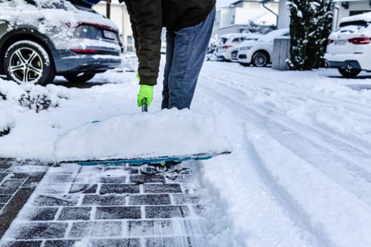 Teenager shoveling snow outdoors on winter day, closeup
