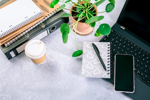 Top view of computer desk with keyboard, smartphone, stationery and coffee cup