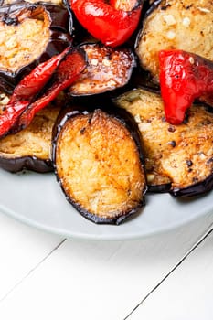 Grilled eggplant and grilled bell pepper on stone or concrete background