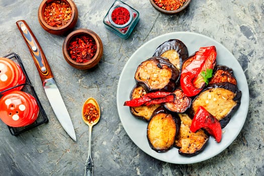 Grilled eggplant and grilled bell pepper on stone or concrete background