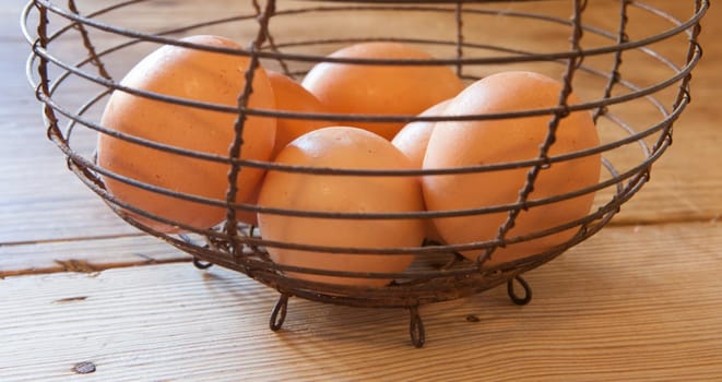 Old rusty wire egg cup. Country style background. Long format